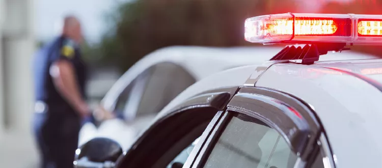 cop car with a police officer out of focus at another car dwi/dui defense