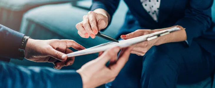 two professionals looking at a contract holding the contract n their hands business law